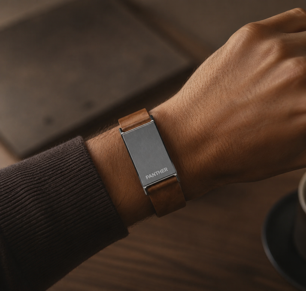 The Panther Eclipse on a wooden display stand, brushed steel face with PANTHER engraving and tan leather strap